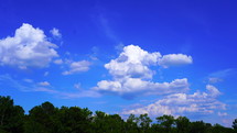 white clouds moving through a blue sky 