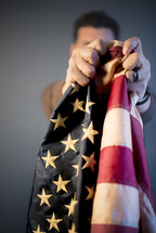 a man holding out an American flag 