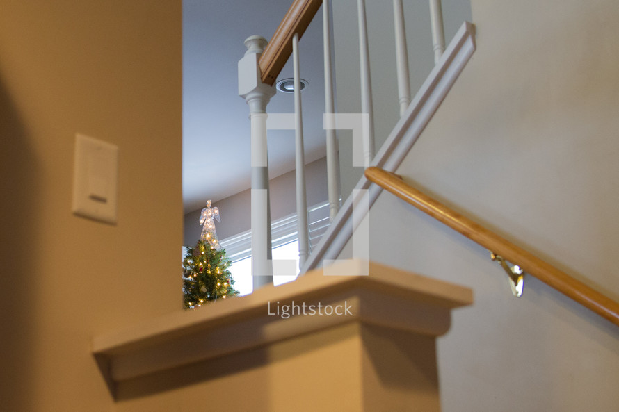 angel on top of a Christmas tree and staircase 