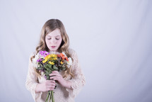 a little girl holding a bouquet of flowers 