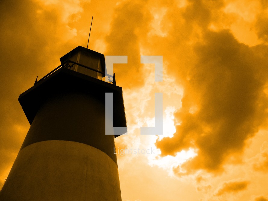 lighthouse against a fiery sky at sunset 