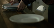 woman placing plates on a table 