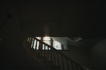 sunlight shining through a stained glass window in a staircase 