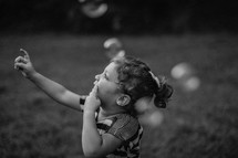 a little girl chasing bubbles 