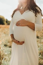 a pregnant woman with her hands on her belly 