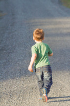 boy child walking on a gravel road 