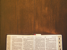 Bible open to Psalms on a wooden table.