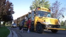 children getting on a school bus 
