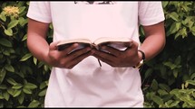 a man opening and reading a Bible 