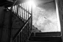 sunlight shining in a stairwell of a basement of an old deserted house