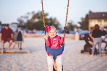 little girl on a swing at the beach 