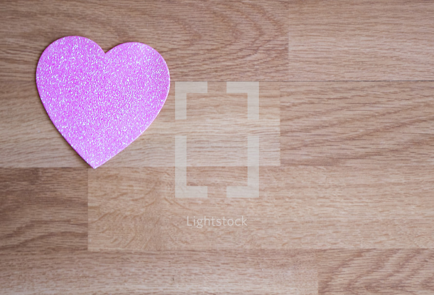 pink heart on wood background 