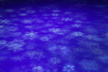 Shapes of white snowflakes on a blue background.