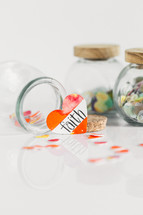 Jars of paper hearts on a white background with one lettered FAITH in front.