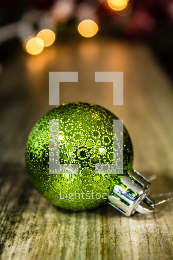 green Christmas ornament on a wood floor 