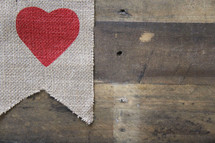 red heart on burlap on a wooden background 