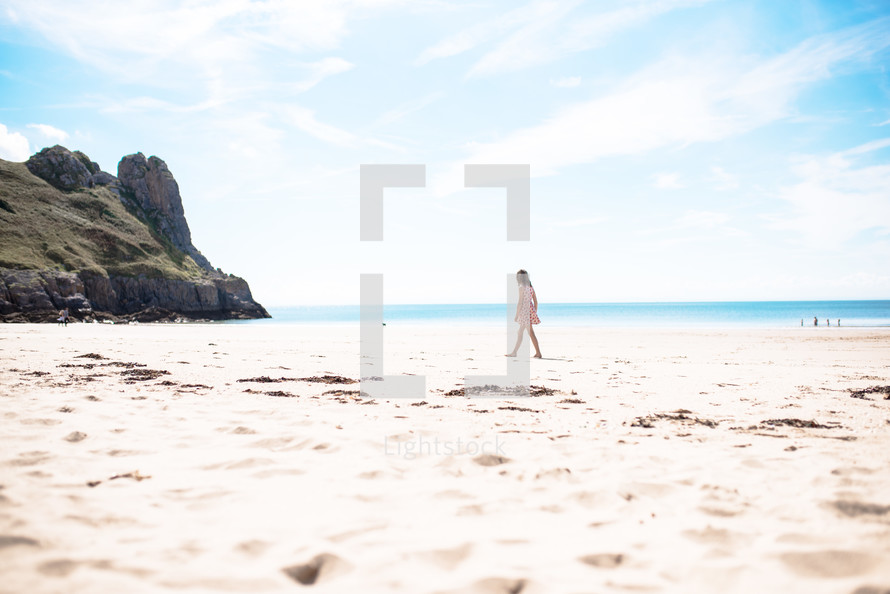 a girl walking on a beach 