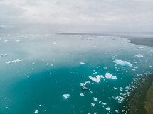 aerial view over chunks of ice floating in the ocean 