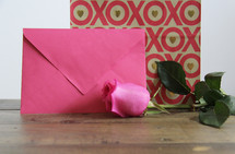 pink rose, envelope, and wrapped gift 