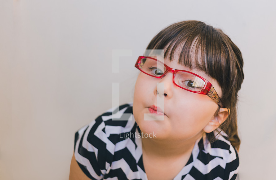 face of a girl child in reading glasses 