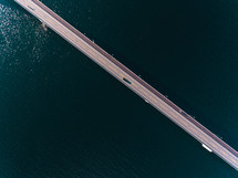 aerial view over a long bridge over water 