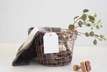 wire basket, linen, fabric, eucalyptus, stamp, twigs, gift tag, ribbon, copper 