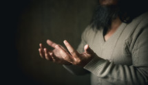Man praying with outstretched hands