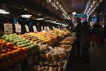 people shopping for produce in a market 