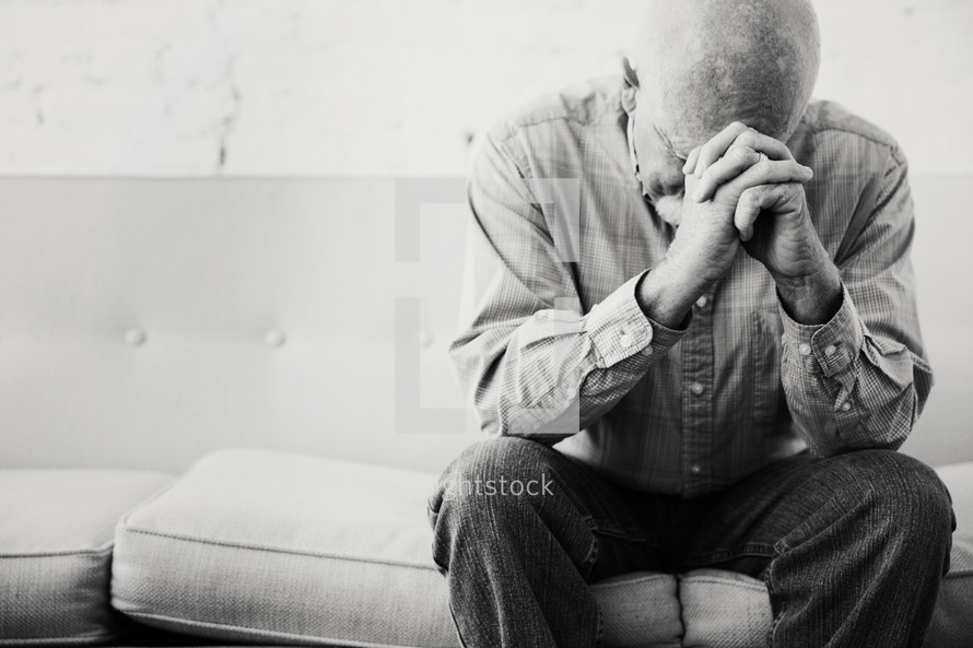 a man with head bowed in prayer 