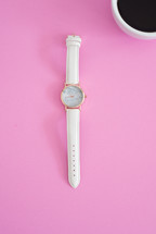 watch and coffee cup on a pink background 