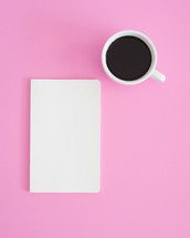 journal and coffee mug on a pink background 