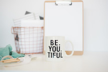 clipboard, Be. You. Tiful, mug, coffee mug, paint brushes, wrapped, ribbon, fabric, countertop, wire basket, paper, journals