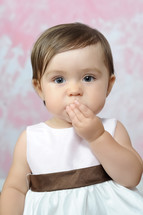 Infant girl blowing kisses.