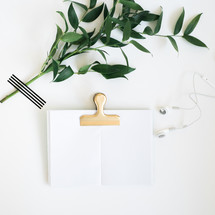 greenery, book clip, journal, and earbuds 