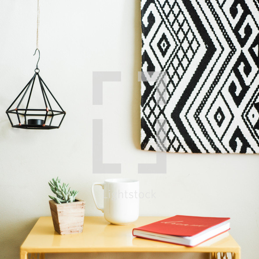 painting, artwork, hanging, candle, house plant, table, coffee mug, journal, decor 