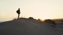Man with open arms on sand dune