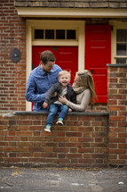 young family looking over a brick fence 
