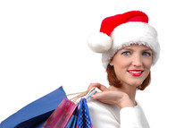 A woman in a Santa hat carrying shopping bags.