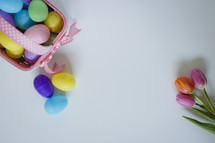 plastic Easter eggs in a basket and tulips 