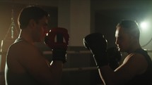 Athletes train fighting in the ring in the gym with boxing gloves
