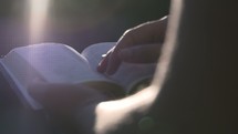 woman reading a Bible in sunlight 