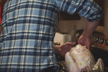 a man stuffing a turkey 