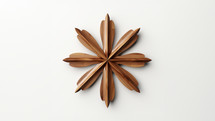 A wooden handmade cross start made by the end of arrows. Set against a white background. 
