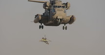 Soldier being taken up by a military transport helicopter during an army rescue operation.