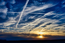 plane contrails in the sky at sunset 