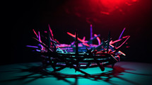 Crown on thorns in dramatic neon lighting. 