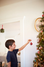 boy decorating a Christmas tree 