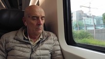Elderly man is traveling by train and sleeping