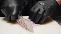 Cutting and slicing small pieces of onion for a dish