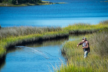 Fisherman throws net to catch shrimp in the salt marsh in The Cedar Point Recreational area along the White Oak River in Carteret County North Carolina, Croatan National Forest